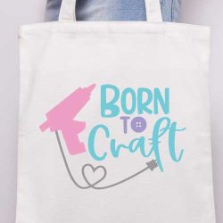 Vertical - Someone holding a canvas tote with the "born to craft" svg design with glue gun applied in iron vinyl