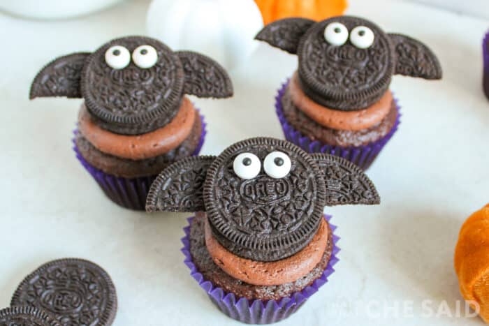 Close up of oreo bats on top of a chocolate cupcake in horizontal format