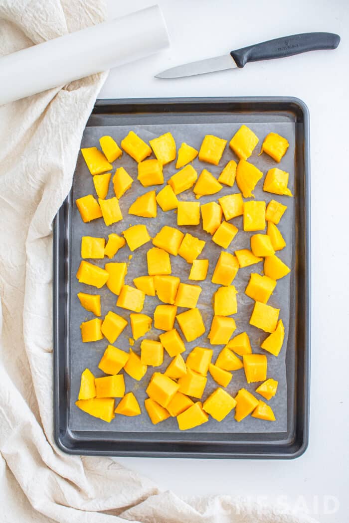 cubed mangoes on sheet pan heading into the freezer